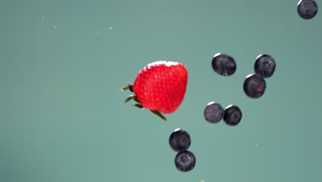 Super-Zeitlupe:-Frisch-Geschnittene-Erdbeeren-Stoßen-In-Der-Luft-Vor-Blauem-Hintergrund-Gegen-Blaubeeren.-Aufgenommen-Mit-Hochgeschwindigkeitskamera,-420 fps